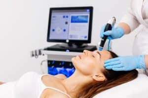 Woman receiving a HydraFacial® treatment, with a skincare specialist using advanced technology to cleanse, exfoliate, and hydrate her skin for a radiant complexion