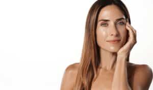 A radiant woman in her 40s shows off glowing, hydrated skin after a cosmetic spa treatment, highlighting the rejuvenating effects of microneedling
